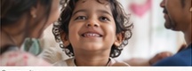 Father holding smiling young boy during community outreach session